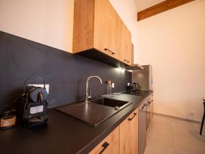 eine Küche mit einem Waschbecken und einer schwarzen Arbeitsplatte in der Unterkunft Moderne T4 à Valmorel, 7 pers., 3 ch., parking, casier à ski, linge inclus - FR-1-291-1020 in Valmorel