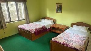 A bed or beds in a room at New Pokhara Lodge - Pokhara Lakeside