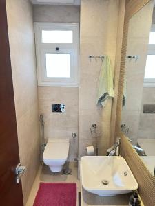 um banheiro com uma pia, um vaso sanitário e uma janela em Compound Hyde park em New cairo