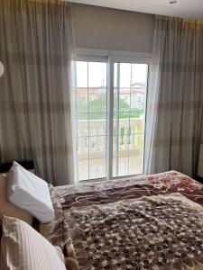 um quarto com uma cama e uma janela grande em Compound Hyde park em New cairo mais 3 fotografias