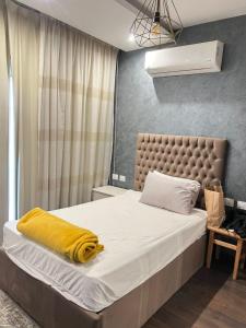 um quarto com uma cama com um cobertor amarelo em Compound Hyde park em New cairo