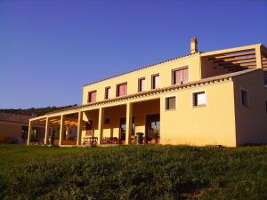 een groot wit gebouw op een grasveld bij Agriturismo La Grotta Del Tesoro in Santadi