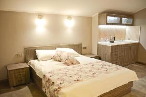 a bedroom with a large bed and a sink at Хотел ЛОНДОН in Svilengrad