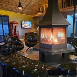 a fireplace in a bar with leather chairs and a phone booth at 7Sense Nature Resort in Sapanca