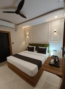 ジャバルプルにあるHotel Onyx Inn Zero Degreeのベッドルーム1室(大型ベッド1台、シーリングファン付)