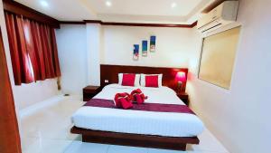 ein Schlafzimmer mit einem großen Bett mit roten Kissen in der Unterkunft 水果天堂旅馆Fruit Paradise in Patong Beach + 2 Fotos