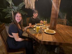 a woman and boy sitting at a table with food at Calm Side Villa Hikkaduwa in Hikkaduwa