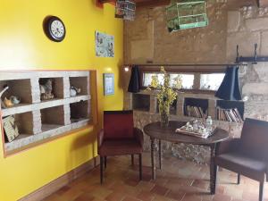 a dining room with a table and chairs and a yellow wall at Domaine les Galards in Le Garde