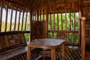a wooden porch with a table in a gazebo at The Apiary Mountain Camp and Farm in Tanay