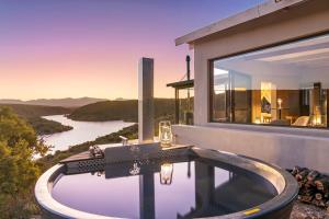 a bathtub in a house with a view of a river at Aardvark Bioreserve in Ladismith