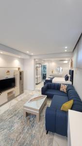 a living room with two blue couches and a tv at luxury studio's J&M in Sarandë