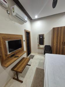 ジャバルプルにあるHotel Onyx Inn Zero Degreeのベッド、テレビ、テーブルのある寝室 +11枚の写真