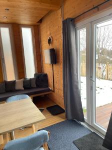 una camera con divano, tavolo e finestra di Tiny House Lodges Zillertal a Unterberg
