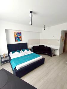una camera da letto con un letto grande e un divano di Eduard Elegance Rin Studios a Bucarest