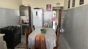 eine Küche mit einem Tisch und einem weißen Kühlschrank in der Unterkunft Casa temporada Angra e Paraty in Angra dos Reis