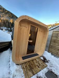a wooden sauna on top of a house in the snow at Ski Lodge Pampeago in Tesero