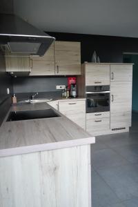 a kitchen with wooden cabinets and a counter top at "Petite perle en Haute Ardenne" avec vue sur la vallée, cabine infra-rouge et bain balnéo in Lierneux +59 photos