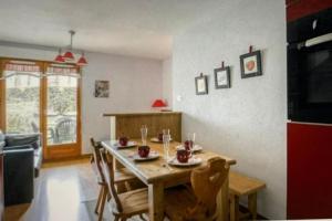 a table and chairs in a living room with a kitchen at Petit cocon entre lac, golf et montagne, proche d'Annecy in Giez
