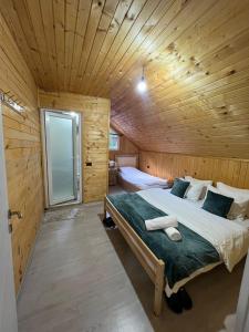 a bedroom with a bed in a wooden cabin at Bujtina Arlindi in Valbonë +50 photos
