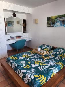 um quarto com uma cama com uma mesa e uma secretária em Serenity Tartane em Tartane