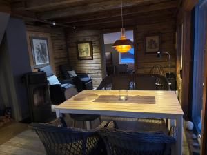 a dining table and chairs in a room with a living room at Lyngen Biarnes- Nordreisa in Rotsund