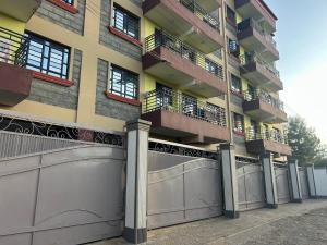 a building with two garage gates and balconies at Cozy studio apartment with balcony in Ngong in Nairobi