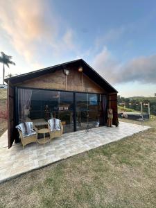 a barn with a table and chairs on a patio at Villa das Cabanas in Salesópolis