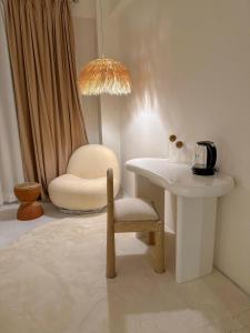 una habitación con una mesa y una silla y una mesa y una lámpara en Lagom Premium Apartment, en Katmandú