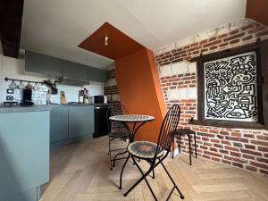 a kitchen with a table and chairs and a brick wall at Haring spot in Arras
