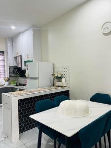 a kitchen with a white table and blue chairs at Inap Kasih Homestay GM in Gua Musang +5 photos