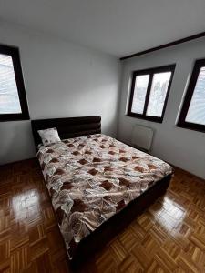a bedroom with a bed in a room with windows at Comfort&Peace in Sarajevo