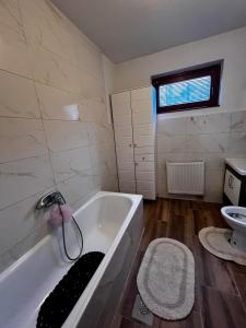 a bathroom with a tub and a toilet and a sink at Comfort&Peace in Sarajevo