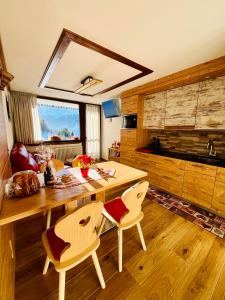 jadalnia z drewnianym stołem i krzesłami w obiekcie Home, sweet home w Livigno