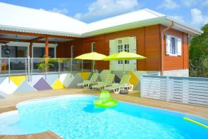 a house with a swimming pool in front of a house at Villa Anj'any DESHAIES - 5 minutes à pieds de la plage in Deshaies