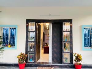 a front door of a building with windows and flowers at Hotel Vijay Greens in Orchha