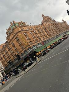 a large building with people sitting outside of it at Chelsea Studio South Kensington 10 Min to Harrods in London