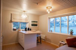 a kitchen with a counter in a room with windows at White House - Panoramic View in Reine