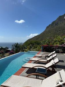 Una fila de tumbonas junto a una piscina. en Paradise Factory St Lucia, en Choiseul