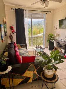 a living room with a couch and a large window at Heiata Lodge Papeete in Papeete +12 photos