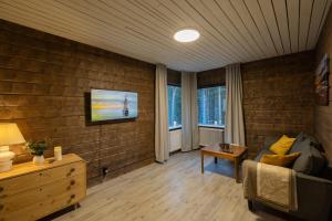 a living room with a couch and a tv on a brick wall at Stuga in Auktsjaur in Auktsjaur +17 photos