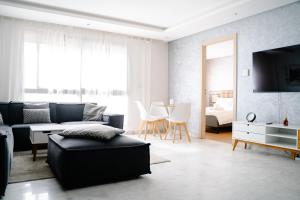 a living room with a couch and a table at Best location, 2 minute to beach in Casablanca +17 photos