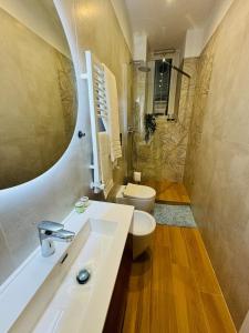 une salle de bain avec un lavabo, des toilettes et une douche dans l'établissement Friendly Apartment San Saba, à Rome