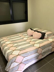 un lit avec deux oreillers dessus dans l'établissement F2 Ti amo 1 chambre, à Saint-Germain-lès-Corbeil