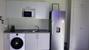 a kitchen with a refrigerator and a washing machine at F2 Ti amo 1 chambre in Saint-Germain-lès-Corbeil