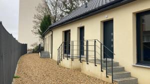 a house with stairs and a fence next to it at F2 Ti amo 1 chambre in Saint-Germain-lès-Corbeil