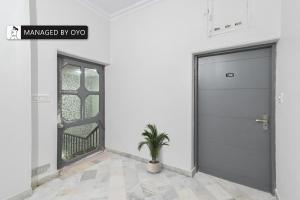 eine Tür in einem Raum mit einer Topfpflanze in der Unterkunft FabHotel Classic Holidays in Jaipur