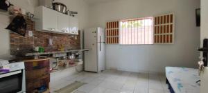 a kitchen with a refrigerator and a window at Mini Recanto da Rosalina in Prado