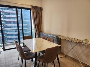 a dining room with a table and chairs and a window at Astoria 4r3b 5minsklcc bathtub waterfilter newcondo bigbalcony in Ampang