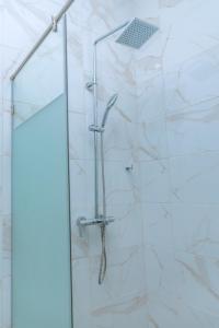 a shower with a glass door in a bathroom at Urban Elite Stay in North Legon +17 photos
