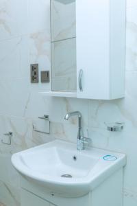 a bathroom with a white sink and a mirror at Urban Elite Stay in North Legon